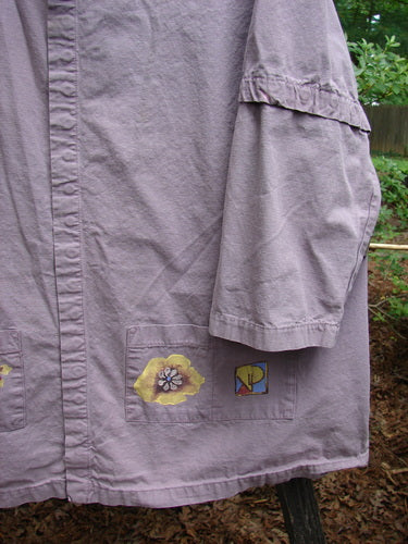 Close-up of the 2000 Parachute Camper Jacket Florals Pale Purple Size 0, showcasing its detailed snap closures and floral-themed painted pockets.