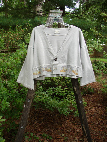 1999 Interlock Solstice Jacket Candle Blue Horizon Size 0 displayed on a wooden ladder, showcasing its wide A-line shape, deep V neckline, two-button front, and wide belled sleeves.