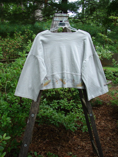 1999 Interlock Solstice Jacket Candle Blue Horizon Size 0 displayed on a wooden ladder, showcasing its cropped length, deep V neckline, and wide belled sleeves.
