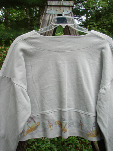 1999 Interlock Solstice Jacket Candle Blue Horizon Size 0 displayed on a swinger, showcasing its wide belled sleeves, deep V-neckline, and holiday-inspired paint, emphasizing its cropped length and unique design.