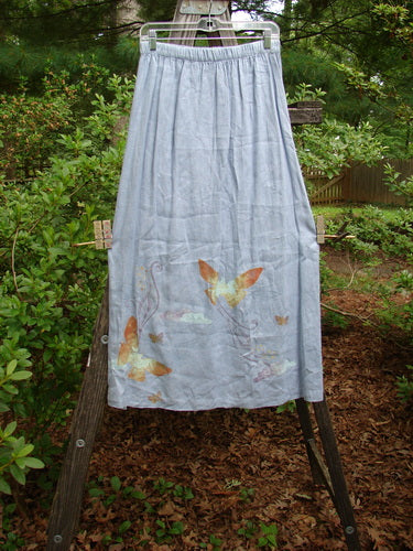 1999 Handkerchief Linen Blossom Skirt Butterfly Water Size 1 displayed on a stand, showcasing its lightweight drape, gradual widening shape, full elastic waistline, and butterfly-themed paint.