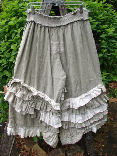 Magnolia Pearl Linen Eiffel Tower Bloomer Flaxen OSFA hanging outside, features loose knee-length design with elastic waist, flared legs, and layered ruffles, embodying a vintage, cottagecore aesthetic.