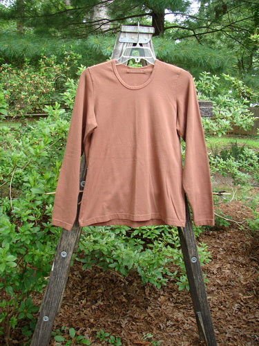 1997 Cotton Lycra Long Sleeved Layering Top Unpainted Copper Size 1 displayed on a wooden rack, featuring a rounded shallow neckline, tapering waist, and slight lower flair.