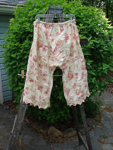 Magnolia Pearl Patched Khloe Bloomer Roses Are Red OSFA features vintage-style knee-length bloomers with a pink and cream floral print, lace trim, drawstring waist, and unique hand-mended details.