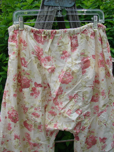 Magnolia Pearl Patched Khloe Bloomer Roses Are Red OSFA, featuring loose-fitting floral-print cotton, hangs outdoors. Highlighted details include a drawstring waist, jester hems, and rose garden patches.