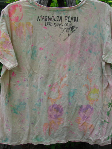 Magnolia Pearl Cotton Jersey Boyfriend Tee ... Is For Lovers OSFA, featuring hand-drawn lettering, a flying figure sketch, and a floral motif, displayed outdoors with pastel tie-dye and distressed shoulders.