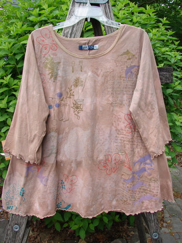Barclay Three Quarter Sleeved Cafe Tee Freedom Forest Garden Beige Size 0 hanging on a rustic ladder, featuring botanical and animal motifs with scalloped edges, set against vibrant greenery.