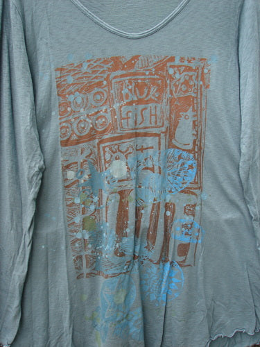 Barclay Modal Long Sleeved A Lined Tee Promo Field Dusky Sky Size 0 features a screen-printed design with stylized fish and utensils, showcasing a casual unfinished hem and slightly wrinkled light-grey fabric.