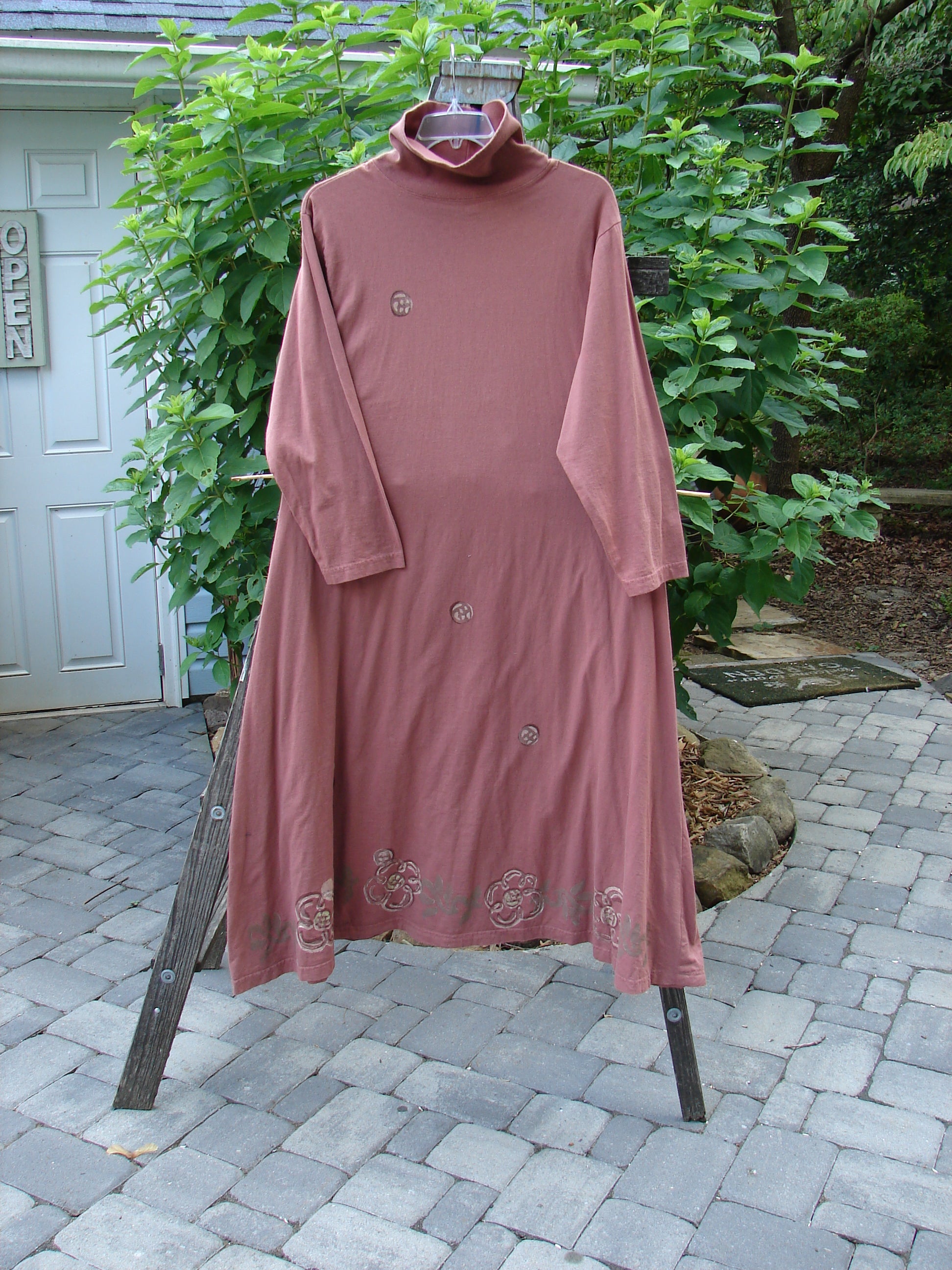 1995 Omega Dress Celestial Garden Altered Clove Size 1 displayed on a stand, showcasing its heavy ribbed turtleneck, drop shoulders, and A-line flare with a drawcord backline.