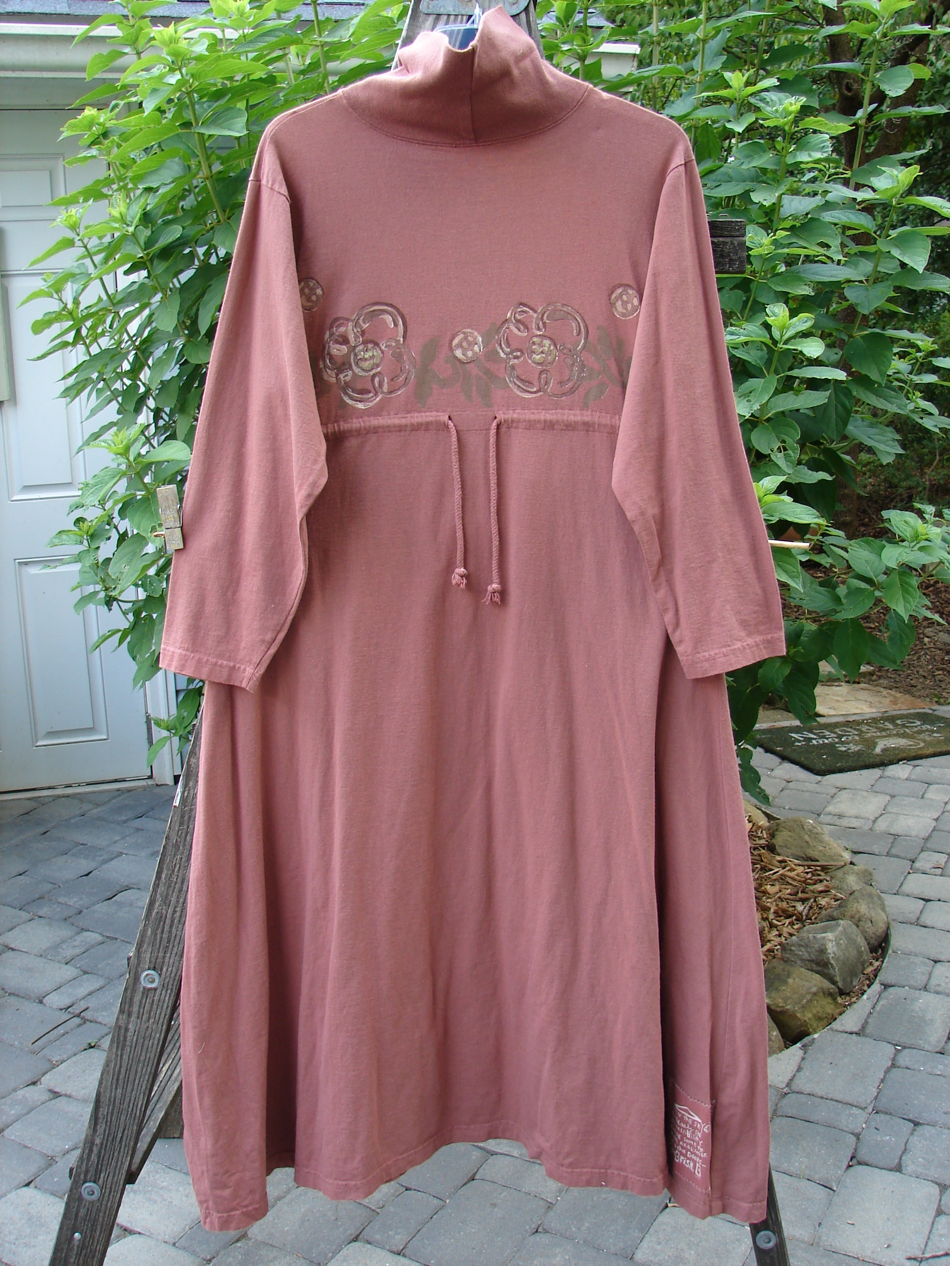 1995 Omega Dress Celestial Garden Altered Clove Size 1, featuring a heavy ribbed turtleneck, drop shoulders, A-line flare, and drawcord backline, displayed on a swing.