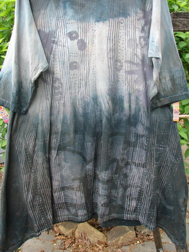 Barclay Wander Tunic Tee Rain Star Mottled Night Size 0, draped on a wooden bench, features a grey-to-black gradient with tie-dye patterns, three-quarter sleeves, and a rounded neckline.