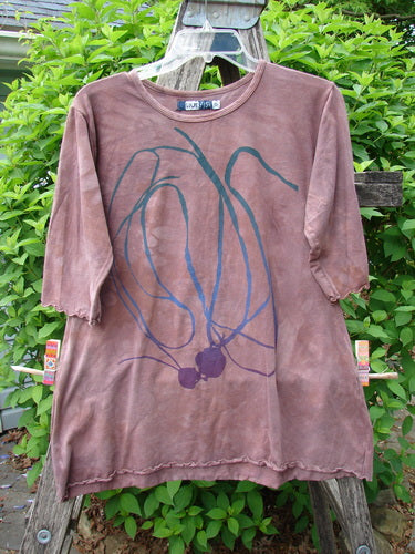 Barclay Cotton Lycra Three Quarter Sleeved A Line Tee Roots Mottled Clay Size 0, featuring a sweeping A-line with abstract green and navy screen-print, displayed on a wooden stepladder outdoors.