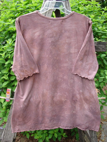Barclay Cotton Lycra Three Quarter Sleeved A Line Tee Roots Mottled Clay Size 0, featuring a mottled brown fabric with scalloped elbow sleeves and a flared hem, displayed on a hanger outdoors.