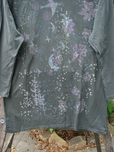 Barclay Long Sleeved Studio Tee Moon Gull Garden Ash Black Size 0, featuring whimsical pastel flowers and birds, hangs outdoors on a rack, showcasing its boxy shape and thin neckline.