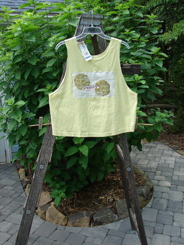 1999 NWT PMU Patched Tank Top Citron Size 0 displayed on a wooden stand, showcasing a scooped neckline and colorful single fish theme patch, ideal for hot summer days.
