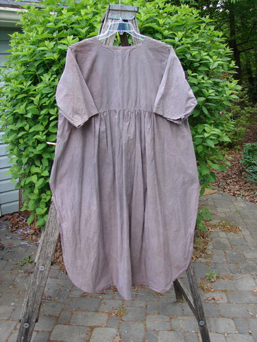 Barclay Percale Key Pocket Hi Low Dress Floral Burst Mocha Size 0, featuring a key neckline, dual drop pockets, and a curved rear gatherer, displayed on a hanger outdoors.