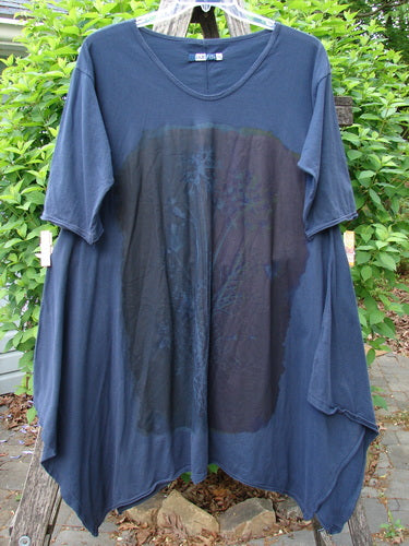 Barclay Origami Tunic Top Night Garden Blue Ink Size 0 features a scooped neckline, elbow-length sleeves, asymmetrical hem, and a faint central print, hanging outdoors against greenery and stone path.