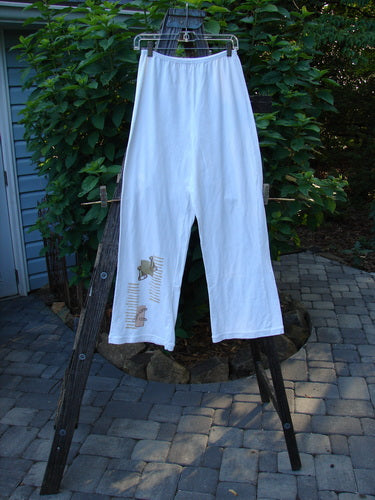 2001 Cotton Lycra Matchstick Pant Junk Drawer Fizz Size 1 displayed on a clothes rack, featuring a painted tea cup design, thin waistband, wide bottoms, and no pockets for a slimming look.