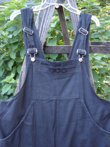 2001 Patched Twill Anisette Overall Pant Jumper Licorice Size 1 displayed on a wooden fence, showcasing the large front painted bib pocket, deep V back, and sectional knee panels.