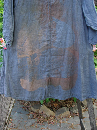 Barclay Linen Lucida Top Metallic Fern Blue Storm Size 0, a slate-blue garment featuring a flowy A-line shape and almost three-quarter sleeves, displayed on a stand with a natural backdrop.