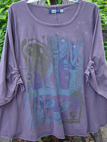 Barclay Draw Gather Sleeve Cafe Top Power Plum Size 0: Women's tunic with a round neckline, ruched sleeves, and abstract print of trees, birds, and stars, hanging outdoors on a hanger.