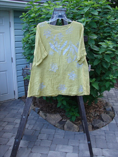 Barclay Light Weight Linen A Line Top Hyacinth Sunshine Size 1 on a rack, showcasing its rounded neckline, three-quarter sleeves, and hyacinth pattern.