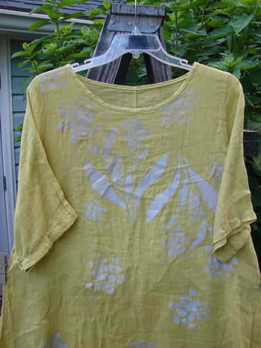 Barclay Light Weight Linen A Line Top Hyacinth Sunshine Size 1 features white floral patterns, rounded neckline, slight A-line fall, and three-quarter sleeves, showcasing a delicate hyacinth theme.