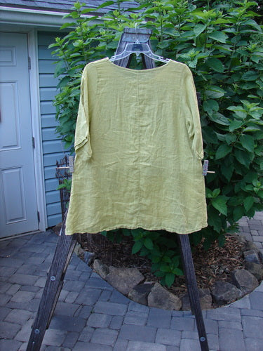 Barclay Light Weight Linen A Line Top Hyacinth Sunshine Size 1 displayed on a swing, showcasing a beautifully rounded neckline, slight A-line fall, and almost three-quarter length sleeves.