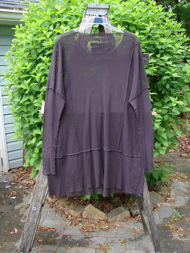 Barclay Patched Cotton Mesh Exterior Stitch Sectional Overtop in Black Cherry hangs on a clear plastic hanger, showcasing its loose fit, long sleeves, wide neckline, and unique exterior stitching.