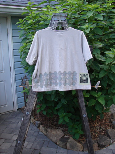 2000 Short Sleeved Crop Tee Floral Fence Dove Size 0 displayed on a wooden ladder, showcasing its wider neckline and super wide crop box shape.