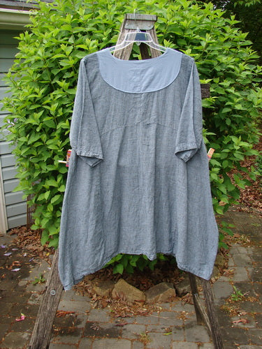 Barclay NWT Linen Cross Over Urchin Dress Unpainted Stripe Sky Size 1, displayed on a wooden ladder, showcasing its loose fit, long sleeves, crossover V-neck, and distinctive drop side pockets.