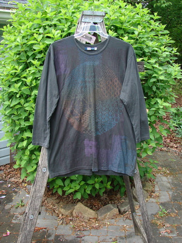 Barclay NWT Long Sleeved Studio Tee Celtic Medallion Smoke Size 0 draped over a wooden stepladder, showcasing a subtle iridescent mandala graphic on its front, highlighting its artistic and organic design.