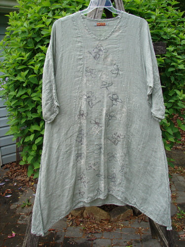 Barclay Linen High Vent Venetian Dress Contour Floral Sage Size 1, featuring a v-neck, crinkled texture, floral motifs, and three-quarter sleeves, hangs outdoors, showcasing its elegant, vintage-inspired design.