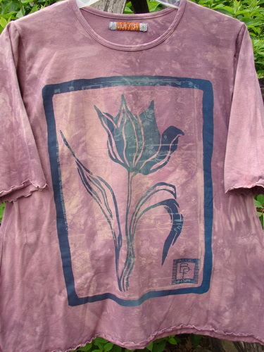 Daisy Hagey Barclay cotton Lycra three-quarter-sleeved cafe tee in mottled mauve, with a single tulip graphic and a leafy outdoor background.