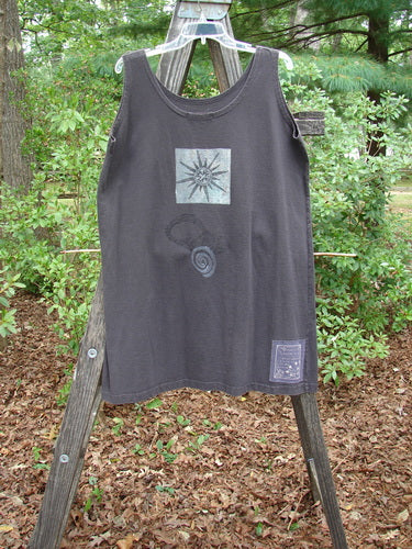 1995 Sun Glint Tank Atom Briquette OSFA displayed on a wooden ladder, featuring a sun design.