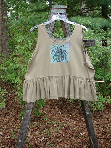 1992 Peplum Top Beetle Wheat OSFA displayed on a hanger, featuring a downward yoke waist, wide hem, and beetle graphic, embodying BlueFishFinder's vintage, artistic style.