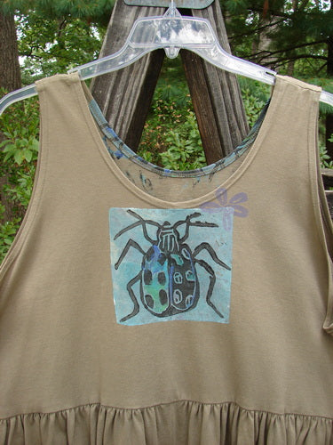 1992 Peplum Top Beetle Wheat OSFA: Mid-weight cotton baby doll top with a beetle design, round neckline, high arm openings, yoke waist seam, and gathered bottom flounce.
