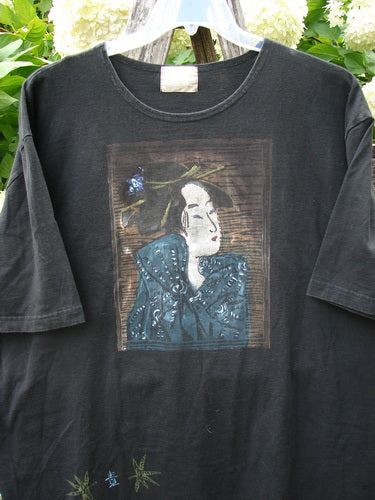 Bluefishfinder.com 1999 Short Sleeved Tee Geisha Gal Black Size 2, a black short-sleeved T-shirt with a faded rectangular geisha portrait printed at the chest and small floral motifs near the hem. The soft cotton knit hangs on a hanger, with a worn vintage look and muted blue, brown, and white tones.