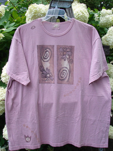 Bluefishfinder.com 1999 Short Sleeved Tee Double Daisy Peony Size 2 in faded lavender cotton, with a relaxed crew neck, loose short sleeves, and two centered floral panels on the chest. The worn fabric hangs from a hanger, framed by green foliage and white blooms.