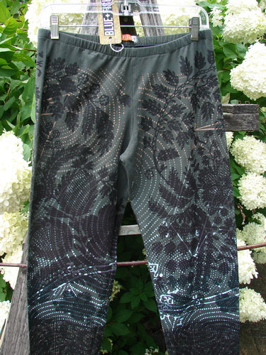 Daisy Hagey Barclay NWT Cotton Lycra Heavy Weight Legging Night Spin Boreal Size 1 in dark boreal green, made of cotton lycra, with a black patterned print and hanging outdoors among white flowers.