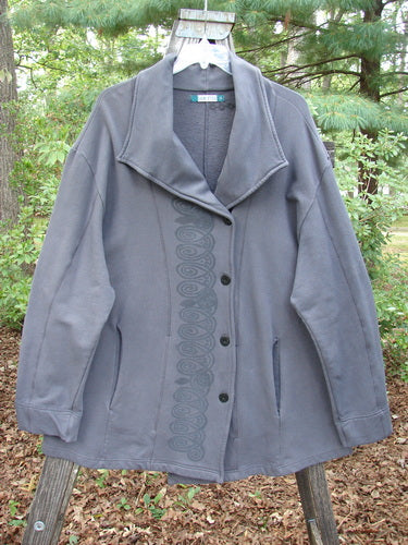 Barclay Interlock Side Button Jacket Sky Plum Size 2 displayed on a wooden pole, showcasing a cozy stand-up collar, wide sleeves, and an offset front button line with curvy seams.