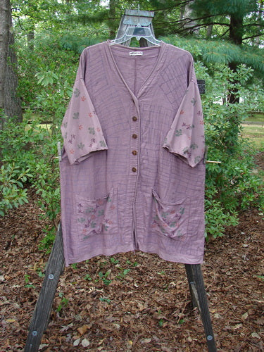 Barclay Linen Cotton Sleeve Pocket Cardigan in Rich Mauve on a rack, featuring floral-printed organic cotton sleeves and wooden button accents, highlighting the cardigan's unique design and craftsmanship.