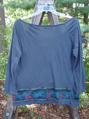 Barclay Batiste Decora Gather Top Gourd Farm Navy Size 1 displayed on a clothes rack, featuring a deep V-neckline, adjustable front drawcord, vertical pleats, and unique farm-themed paint detailing.