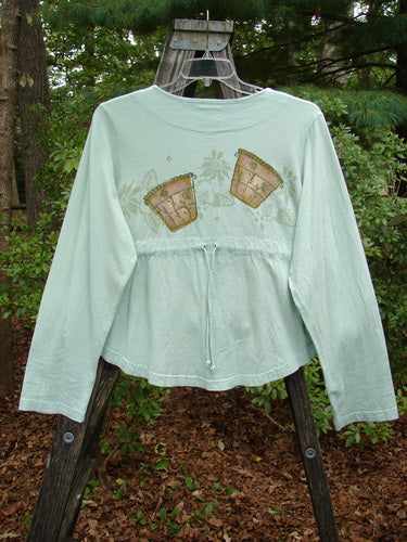 1999 Coffee Top Flowerpot Mint Size 1 displayed on a swinger, featuring a sweeping rounded hemline, ceramic button closures, and a drawcord back, showcasing Blue Fish's vintage, organic cotton design.
