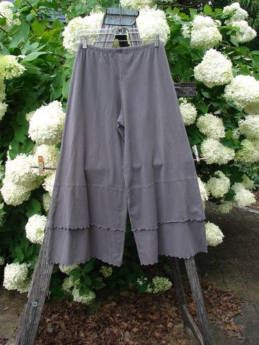 Bluefishfinder.com Barclay Cotton Lycra Crop 2 Petal Pantaloon in unpainted dusty plum, size 0, shown as wide cropped pants with a soft drape, elastic waistband, and scalloped petal hems. The matte fabric hangs from a wooden ladder amid white hydrangeas and green foliage.