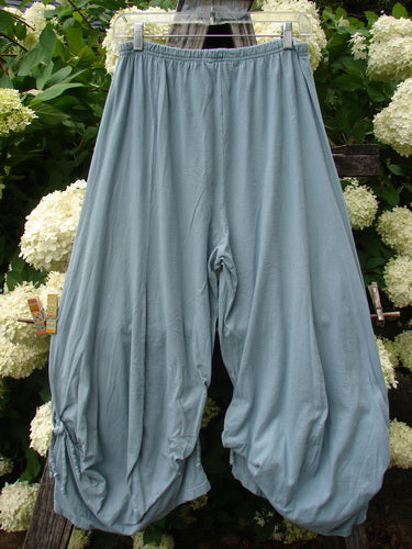 Bluefishfinder.com Barclay Crop Tie Bottom Crop 4 Square Pant in unpainted Blue Cloud, size 0, hangs in a soft, voluminous silhouette with gathered tie hems and a cropped cut. The lightweight fabric falls in smooth folds, set against leafy greenery and white blooms.