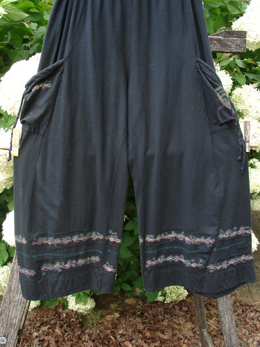 Bluefishfinder.com Barclay Crop Tie Pocket Pinch Pant Wind Chain in black, size 0, with wide cropped legs, tie pockets, and pinch detailing. The lightweight fabric falls in a loose drape, finished with subtle patterned trim along the hem and pocket edges.