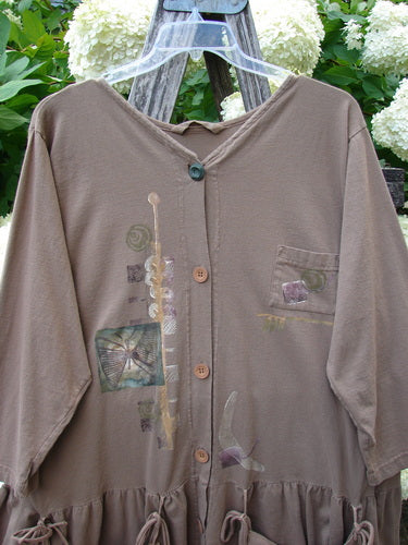 Bluefishfinder.com 1995 Clothespin Jacket Butterfly Mudpie OSFA in muted brown, a soft long-sleeve button-front jacket with a gathered hem and hooded neckline. Its front shows layered butterfly and clothespin motifs, with a small chest pocket and sheer hanger display.