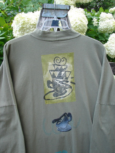 Bluefishfinder.com 1996 Message Top Tumbling Teacup Vine Size 3 in muted olive green, a long-sleeve top with a high mock neck and loose drape. The back features a central graphic of a tumbling teacup and abstract vine motif, printed in faded gray and blue tones.