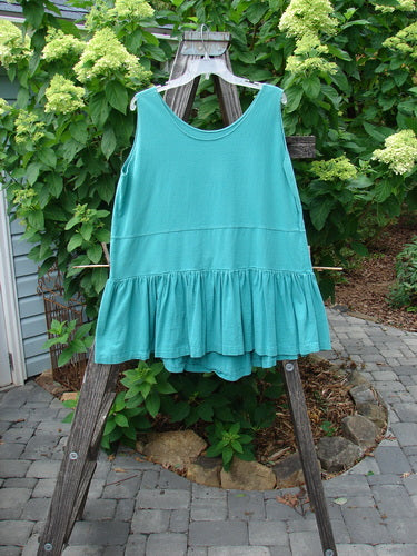 1990 Button Tier Top Unpainted Turq OSFA displayed on a wooden stand, showcasing its drop waistband, gathered flounce, and varying ruffled hemline.
